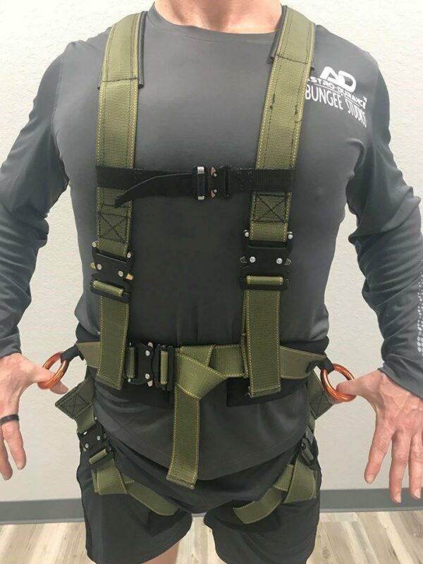 Tactical harness for outdoor activities, featuring adjustable straps and durable olive green design.