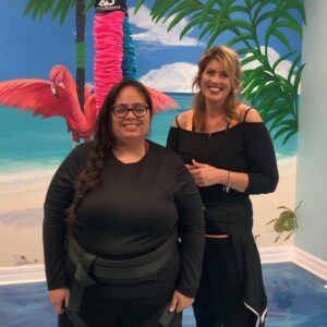 Friends enjoying tropical vibes in a colorful beach-themed room with a vibrant mural.