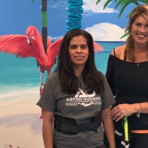 Friends smiling together by a vibrant tropical beach mural, exuding warmth and positivity.