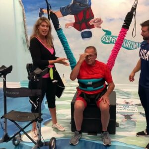 Emotional support in bungee therapy session at a rehabilitation center with engaged therapists.